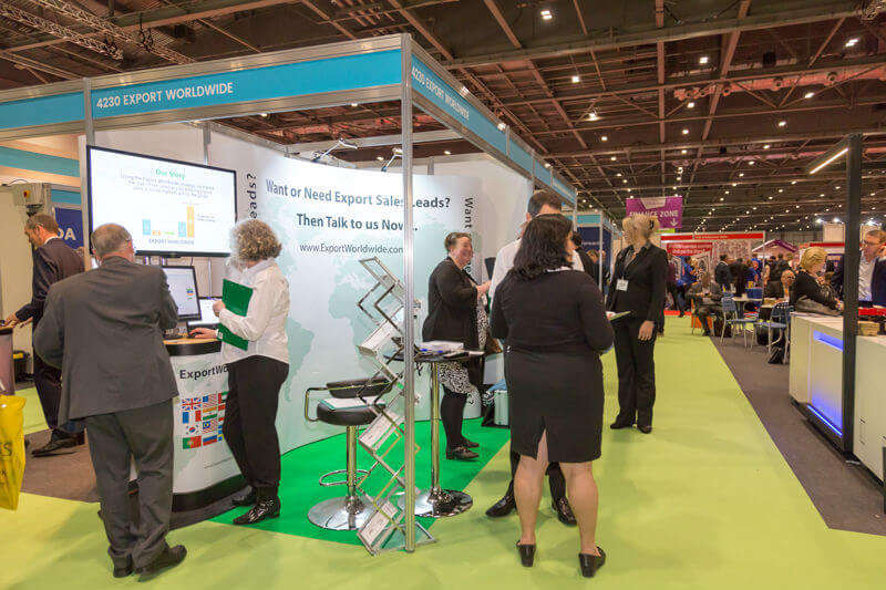 People talking at a trade show stand - successfully taking advantage of trade shows