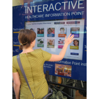 En kvinde ved hjælp af et gennem vindues selvbetjening berøringsskærm kiosk