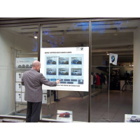 A man using a PCAP touch foil interactive shop window