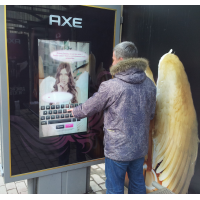 A man using a 32 inch touch screen overlay display at a bus stop