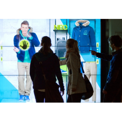 A couple using a large format touch screen display shop window