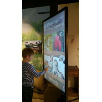 A boy using an interactive totem from leading touch screen foil manufacturers