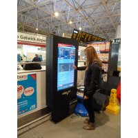 A girl using a touch screen ticket machine timetable at an airport