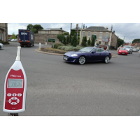 Basic sound level meter being used at a roadside.