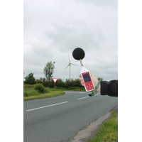 An Optimus environmental and occupational noise measurement device being used outside by a road.