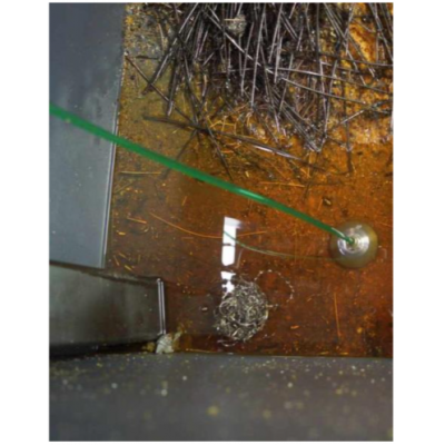 Sistema de recuperación de aceite de corte con cabezal deslizante en uso en un depósito de virutas.