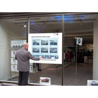 Seorang pria menggunakan jendela toko interaktif sentuh PCAP