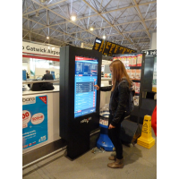 Een meisje die een het tijdschema van de aanrakingskaartkaartmachine gebruiken bij een luchthaven