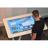 Człowiek używający interaktywnego stołu z interaktywnym ekranem dotykowym