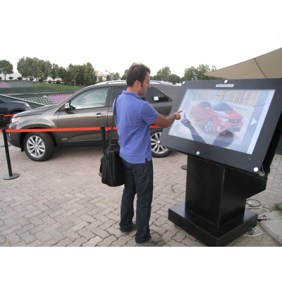 Człowiek używający 55-calowego ekranu dotykowego z nakładką na kioski
