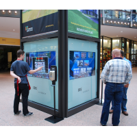 Bir alışveriş merkezinde interaktif bir yol bulma kiosk kullanan insanlar
